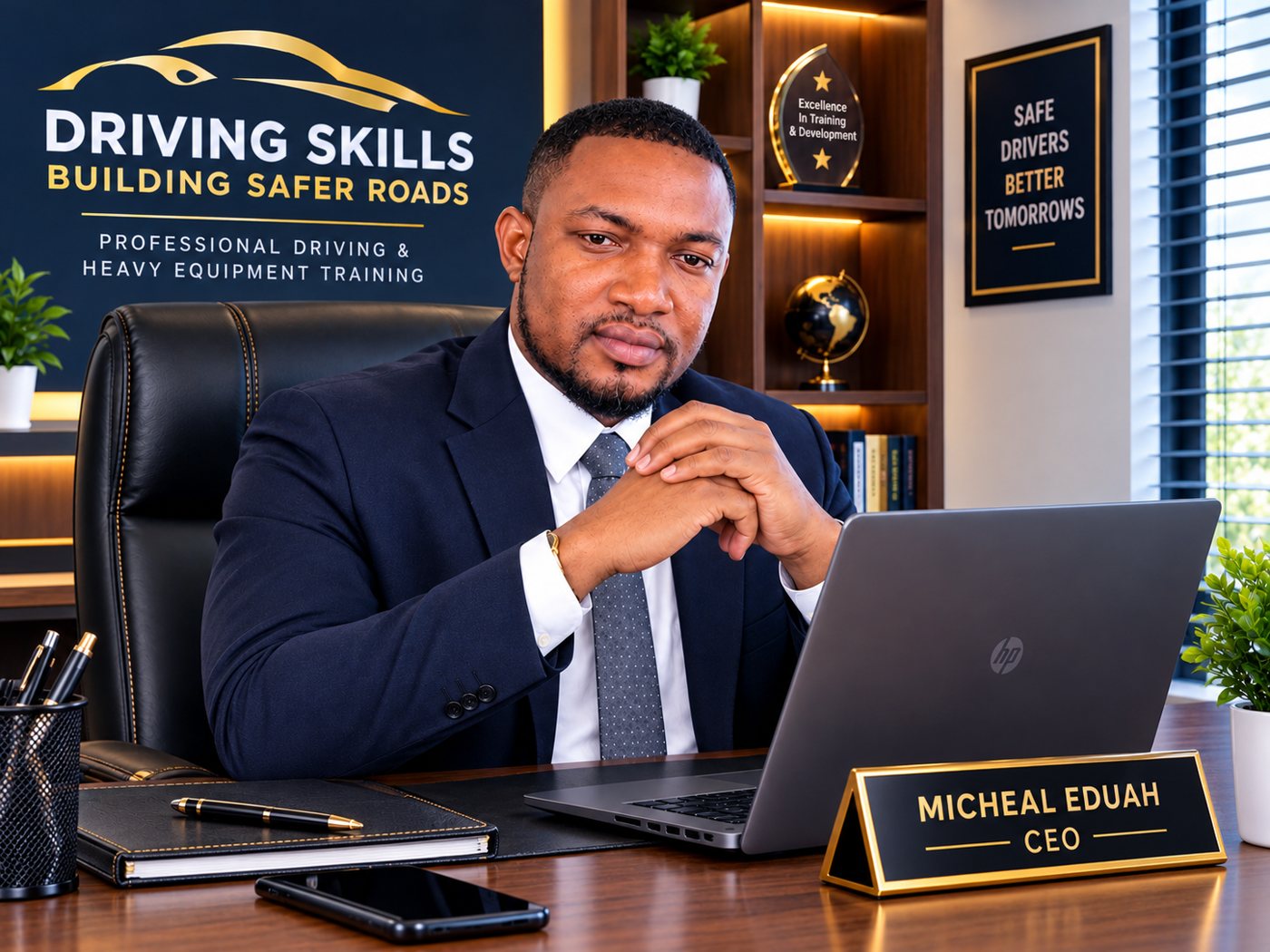 Micheal Eduah, CEO of Gracious Pearl Driving Academy, seated at his desk